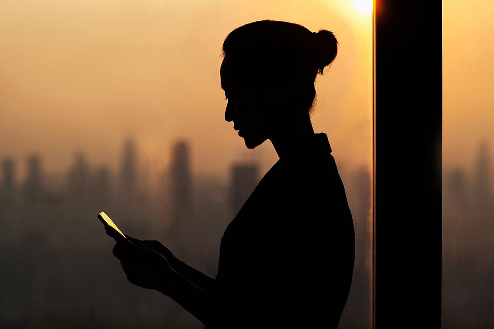 Woman on her phone in front of a skyline