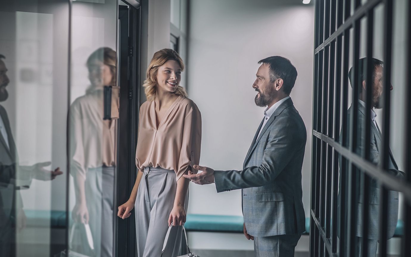 Man holds up door for woman