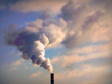 Smoke emerges from a factory smokestack