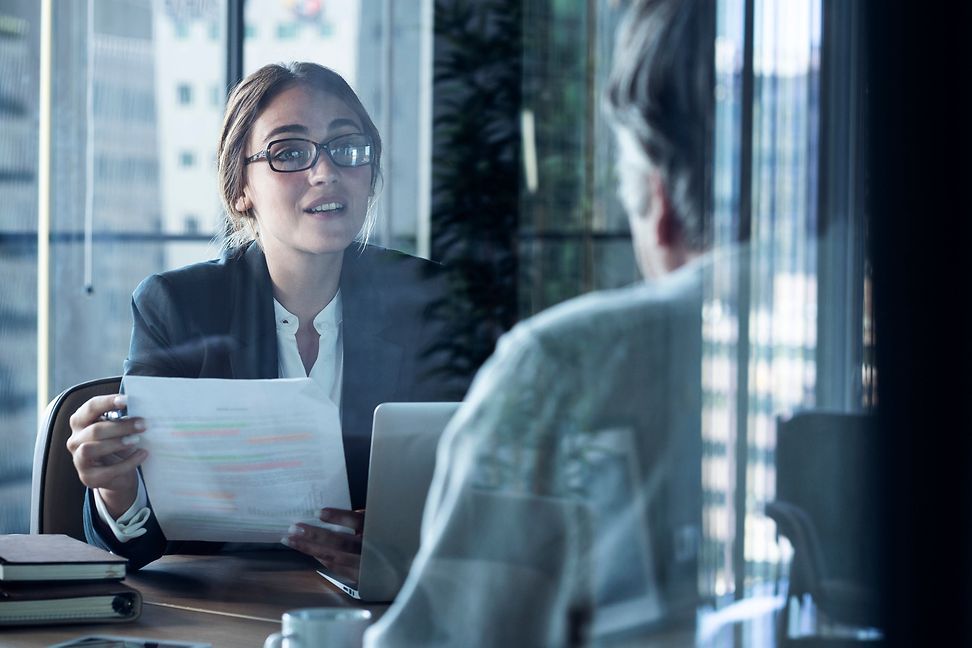 A woman advises a man in an office setting