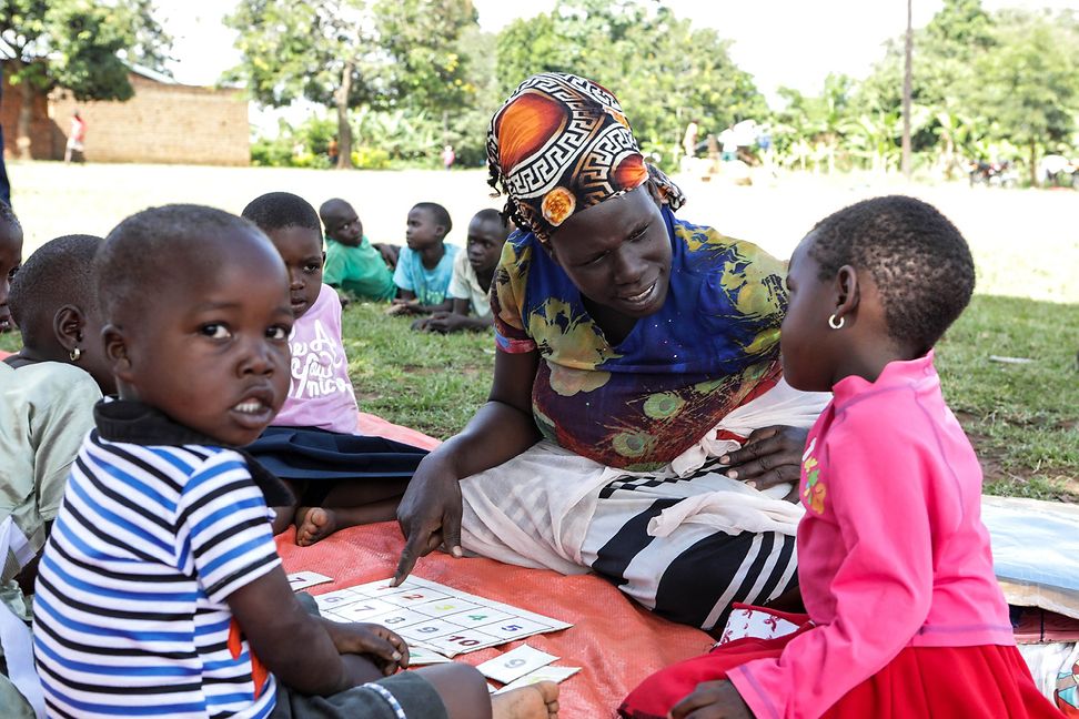 A volunteer teaching two children