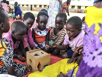 A group of small children playing with colourful toys