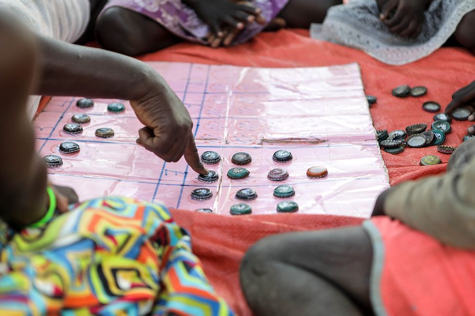 A woman's hand showing something on a boardgame