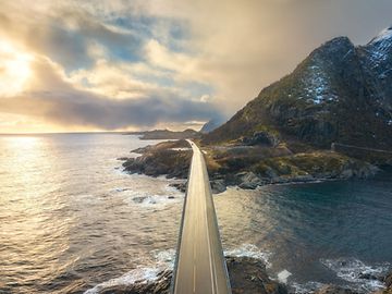 A bridge spans the water in a rocky landscape by the sea