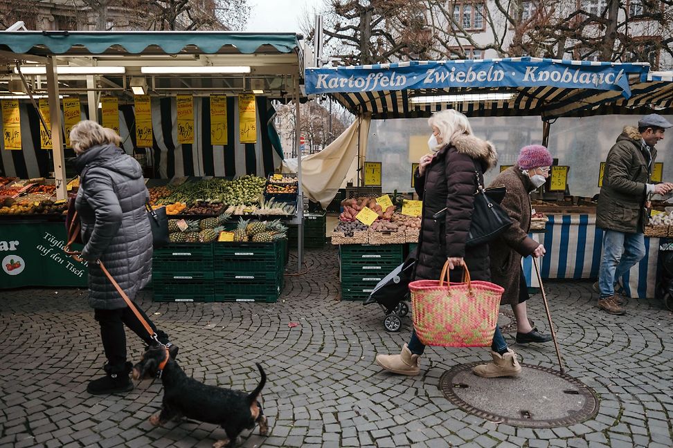 People walk past stalls at a weekly market