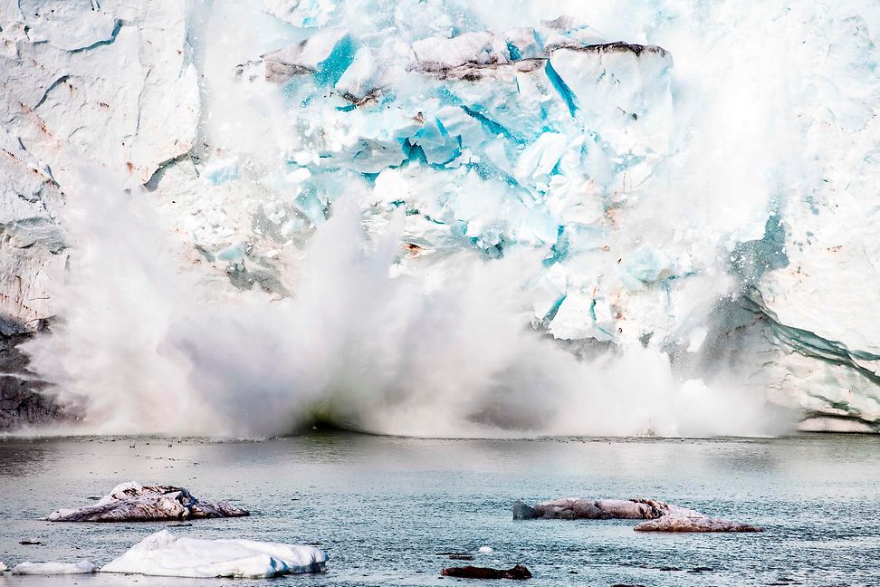 Pieces of an iceberg or glacier fall into the water