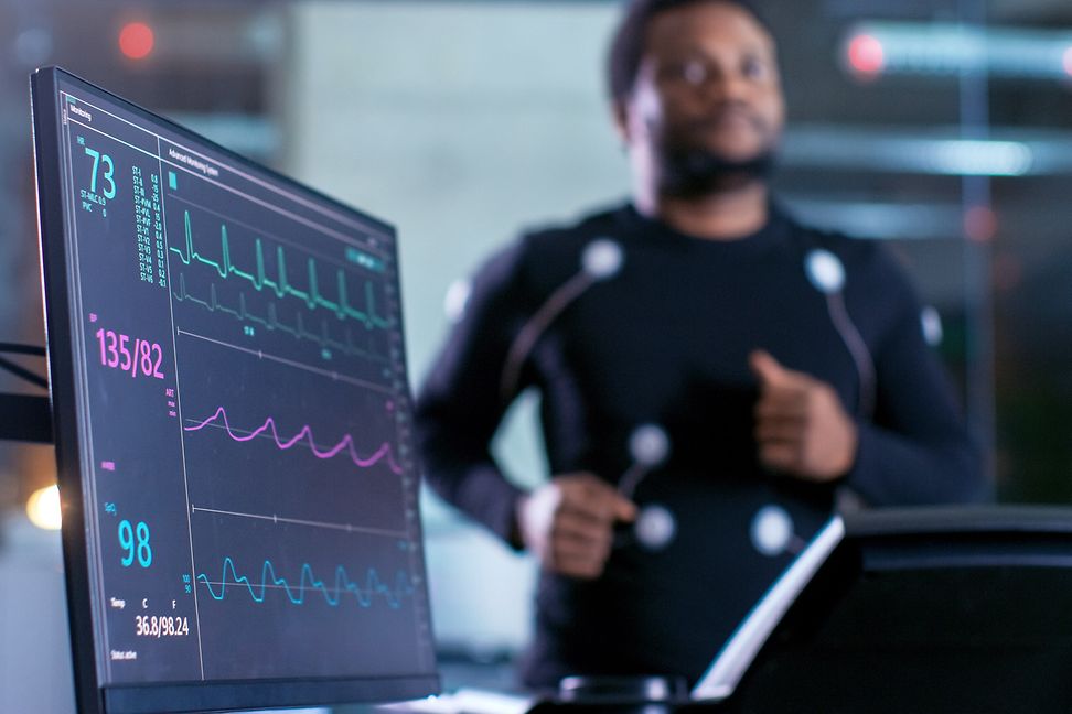 A man exercises while a medical device measures his vital signs.