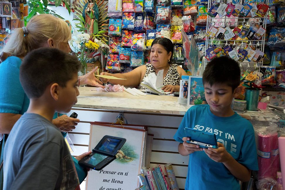 A woman stands behind the counter of a shop specialising in party goods.