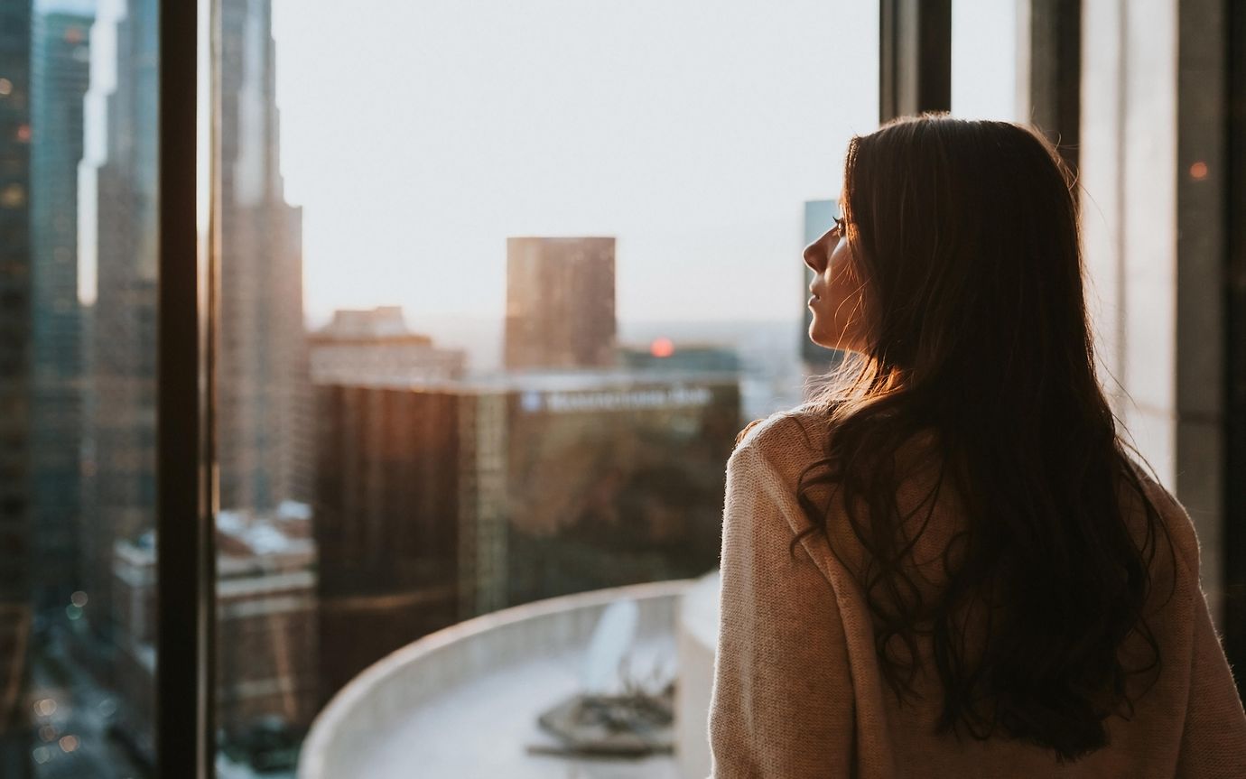 side profile of woman looking outside window