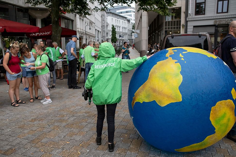 Greenpeace activist next to a balloon in the shape of the globe