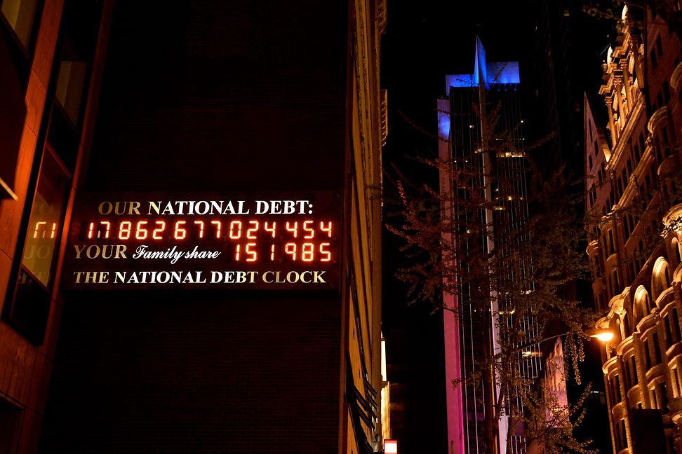 On top of a skyscraper in a big city, a digital display with large numbers is lit up.