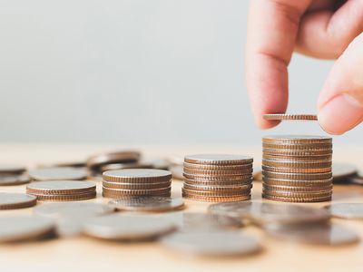 hand adds to ascending stacks of coins